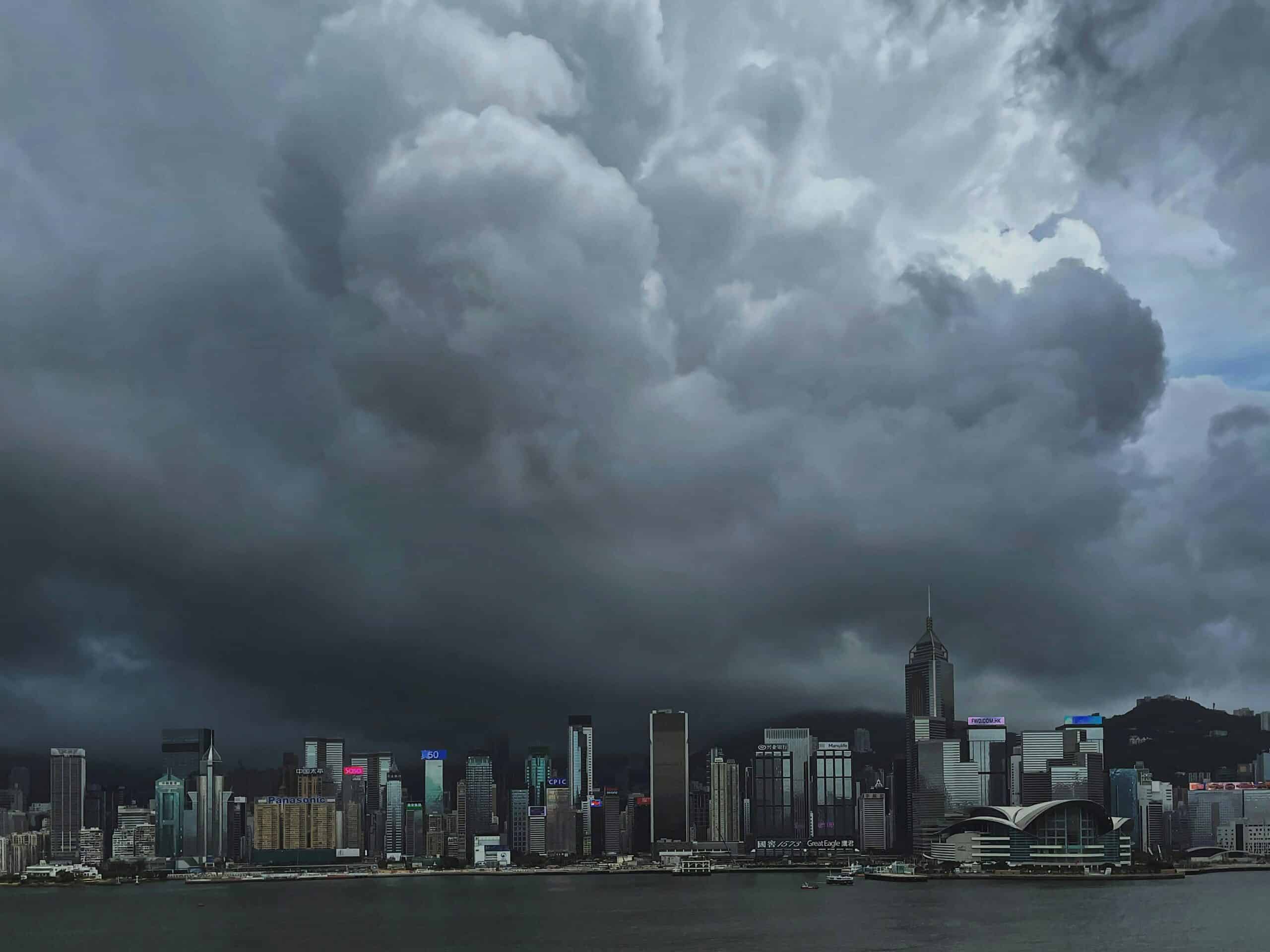 A striking view of storm clouds looming over Hong Kong's iconic skyline and harbor.